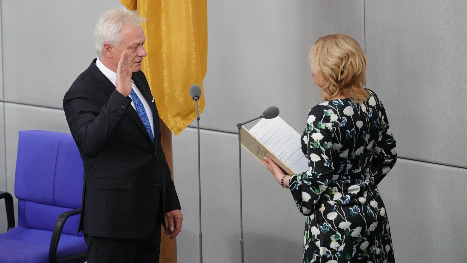 Alois Rainer raising his right hand to take the oath of office in the Bundestag chamber, facing the President of the Bundestag
