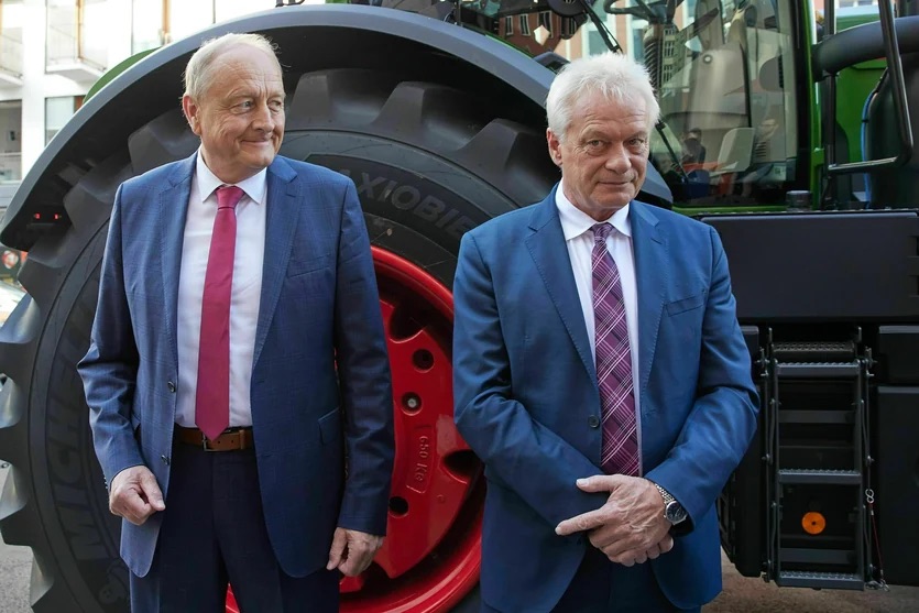 Alois Rainer and another man standing in front of a large tractor
