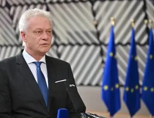 Alois Rainer speaking to the press in front of EU flags