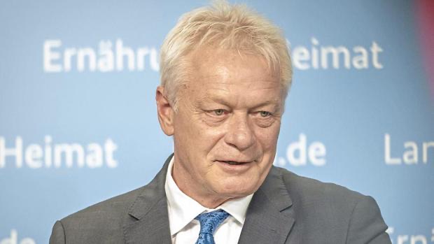 Alois Rainer speaking at a press event in front of a ministry backdrop with the words Ernährung and Heimat